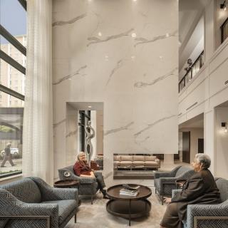 A modern lobby with tall ceilings and comfortable seating, bathed in natural light.