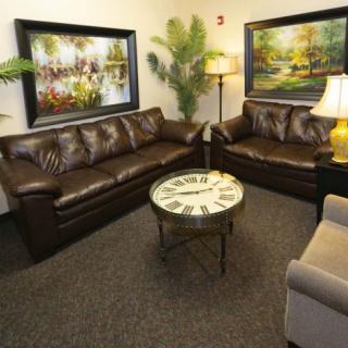 A cozy living room with leather sofas, a decorative coffee table, and wall art.