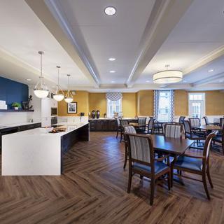 A modern dining area with neatly arranged tables and chairs, featuring elegant lighting and a stylish interior design.