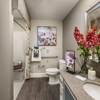 A modern bathroom with floral decor and stylish artwork.