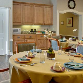 A cozy dining area with a neatly set table and a view into the kitchen.