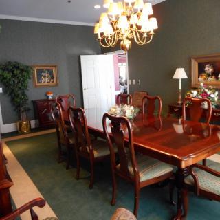 A well-appointed dining room featuring a large wooden table, elegant chairs, and a chandelier.