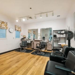 A modern hair salon with styling stations and comfortable chairs.