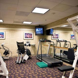 A well-equipped gym with various exercise machines including a treadmill and a stationary bike.
