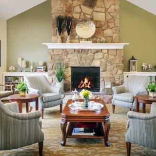 A cozy living room with a stone fireplace and elegant furniture setup.