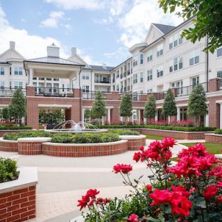 A beautifully landscaped residential building with vibrant flowers in the foreground.