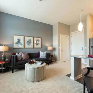 A modern living room featuring a stylish sofa, neutral color palette, and sophisticated artwork.
