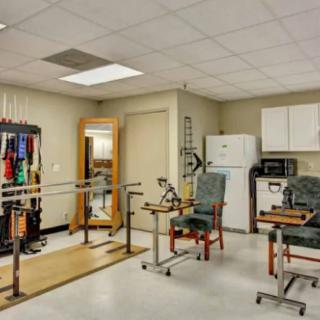 A physical therapy room equipped with rehabilitation tools and parallel bars for patient exercises.