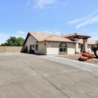 A suburban house with a spacious driveway under a clear blue sky.