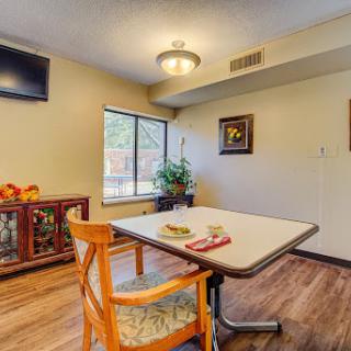 A cozy dining area featuring a table and chairs, complemented by a television and decorative elements.