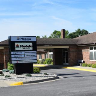 A view of a healthcare facility with clear signage and landscaping on a sunny day.