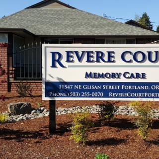 A sign for Revere Court Memory Care facility in front of a building.