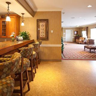 A cozy lounge area featuring a bar with seating and modern decor.