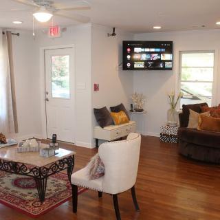 A cozy living room with stylish furnishings and a mounted television.