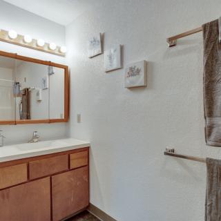 A clean and simple bathroom with a wooden cabinet, mirror, and towel rack.
