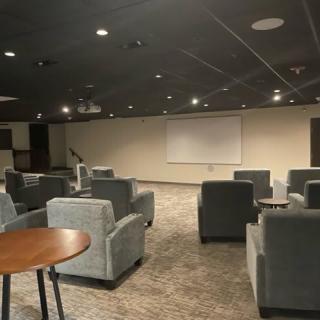 A modern conference room with comfortable seating and a projection screen.