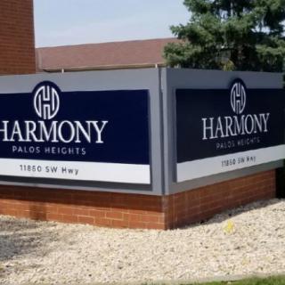 Sign for Harmony Palos Heights outside a brick building.
