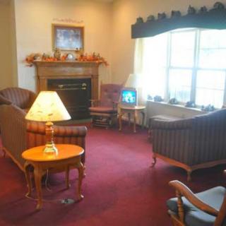 A cozy living room with a fireplace, sofas, and a television.