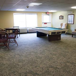 A spacious game room featuring a pool table and seating area.