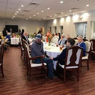 A group of people enjoying a formal dining event in a well-lit indoor setting.