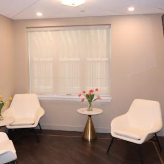 A modern lounge area designed for comfort, featuring stylish chairs and a small table with flowers.