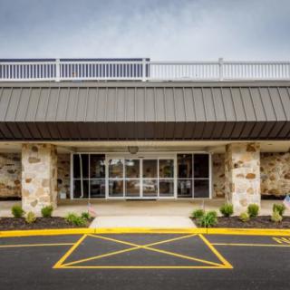 A commercial building entrance with a storefront and parking lot.