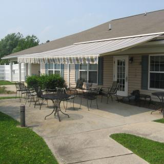 A cozy patio area with outdoor furniture and an awning attached to a house.