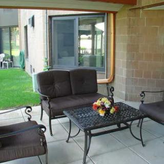 A cozy outdoor sitting area featuring metal furniture and a decorative floral centerpiece.