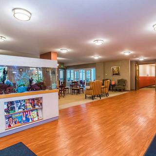 A welcoming lobby area with wooden flooring, comfortable seating, and an aquarium.