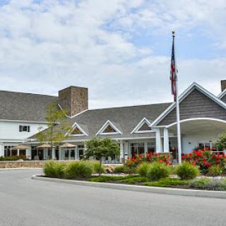 A welcoming front view of a residential building with a flag and well-maintained landscaping.