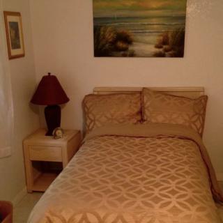 Cozy bedroom with a bed, lamp, and artwork on the wall.