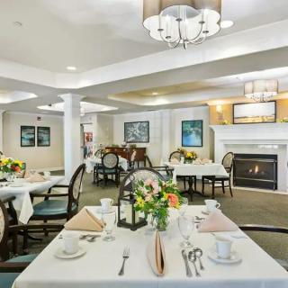 An elegant dining area with beautifully set tables and a cozy fireplace.