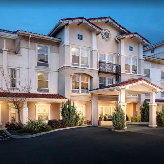 A three-story residential building with a covered entrance, captured during the evening.