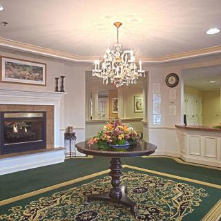 A luxurious lobby with a central table and chandelier.