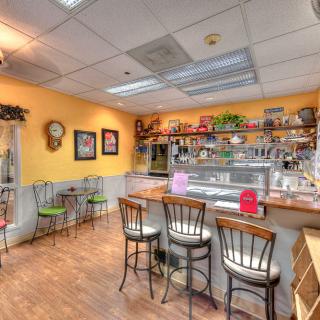 A cozy cafe interior featuring a counter with bar stools and warm decor.