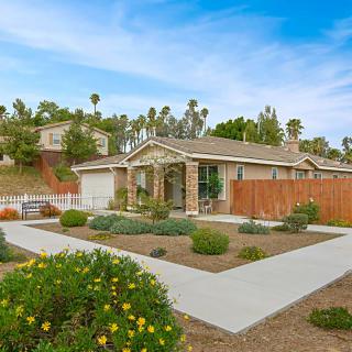 A suburban house with a landscaped front yard and a clear blue sky.
