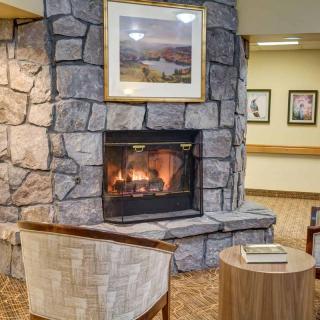 A cozy indoor seating area with a stone fireplace and artwork above it.