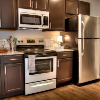 Modern kitchen with stainless steel appliances and dark cabinets.