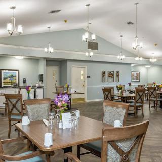 A spacious and well-lit dining area with neatly arranged tables and chairs.