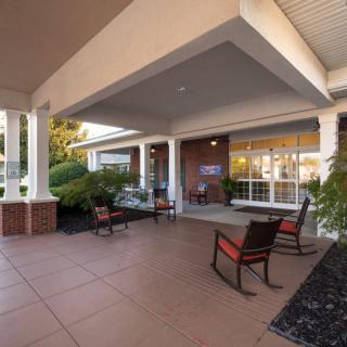 A cozy outdoor porch with rocking chairs under a covered patio.
