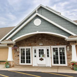A well-designed entrance of a residential building showcasing a mix of stone and siding.