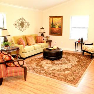 A cozy living room with a sofa, armchair, coffee table, and decorative elements.