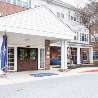 Entrance of a building with flags and an awning.