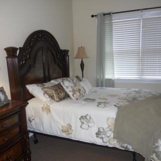 A neatly arranged bedroom with a large bed and elegant decor.