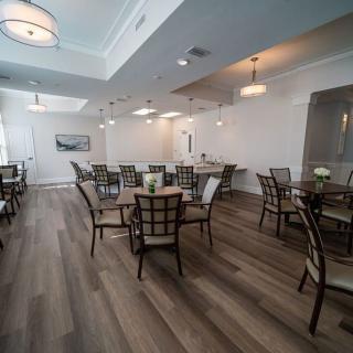 A modern dining area with neatly arranged tables and chairs, featuring elegant lighting and decor.