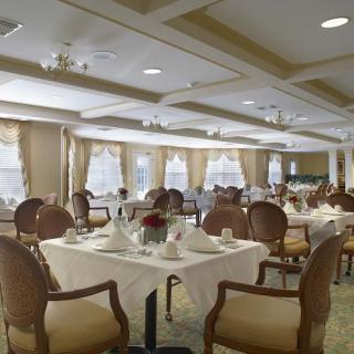 An elegant and formal dining room featuring beautifully set tables and comfortable chairs.