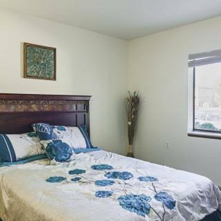 A cozy bedroom with floral bedding and a window letting in natural light.