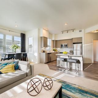 A modern open floor plan featuring a bright living room and kitchen area.