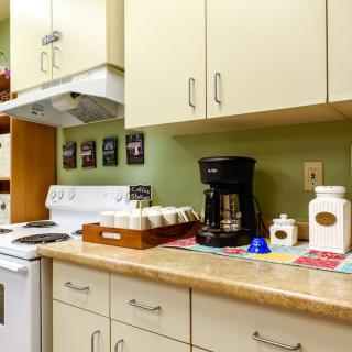 A cozy kitchen setup featuring a coffee maker and neatly organized cabinets.