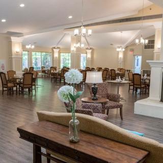 A spacious and elegantly decorated dining area with wooden floors and stylish furniture.
